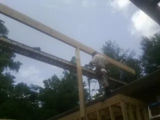 Carpenter setting a ridge beam over a new addition frame — Ice Dam Removal by Roofing Brothers in Prairie Grove