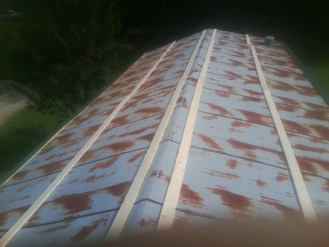 Rusted metal roof panels with new wood purlins before replacement — Storm Damage Roof Repair in Prairie Grove by Roofing Brothers